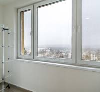 Útulný 2-izbový byt na prenájom - Balkón s výhľadom v 2-izbovom byte, stojan na prádlo, mesto v hmle.