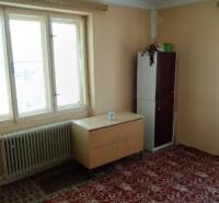 Na predaj rodinný dom Kosihovce - Interiér rodinného domu so skrinkou, stolom a červeným kobercom.