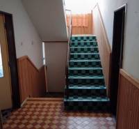 Na predaj rodinný dom Kosihovce - Schodisko s kachličkovou podlahou v rodinnom dome, obložené drevom na stenách.