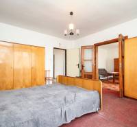 Dom s veľkým pozemkom 3099m2, Melčice-Lieskové - Spálňa so skriňami, posteľou a drevenými dverami, v rodinnom dome.