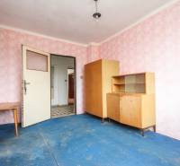 Dom s veľkým pozemkom 3099m2, Melčice-Lieskové - Izba v rodinnom dome so starším zariadením, ružovou tapetou a modrou podlahou.