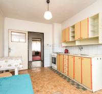 Dom s veľkým pozemkom 3099m2, Melčice-Lieskové - Kuchynská linka v byte s typickým dizajnom. Vidno bielu tehlovú stenu a rodinný dom.