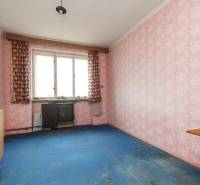 Dom s veľkým pozemkom 3099m2, Melčice-Lieskové - Izba v rodinnom dome s ružovými tapetami, modrým kobercom a vintage záclonami.