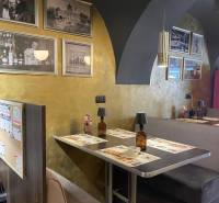 Reštaurácia na predaj v centre Košíc na Hlavnej 74 - Interiér gastro priestorov s dreveným dekorom a historickými fotografiami na stenách.