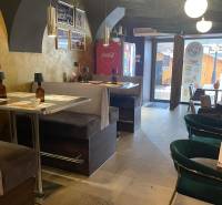 Reštaurácia na predaj v centre Košíc na Hlavnej 74 - Interiér gastro priestoru s pohodlnými sedeniami a dekoračnými svietidlami.