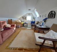REZERVOVANÉ! Predáme 4-izb. rodinný dom, pozemok 1414 m2, Vráble - Podkrovná obytná miestnosť v rodinnom dome s rozkladacou sedačkou a dekoratívnymi doplnkami.