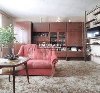 Predaj, rodinný dom Veľký Kýr, šesťizbový s garážou ... - Obývačka v rodinnom dome s červenou sedačkou a drevenou obývacou stenou.