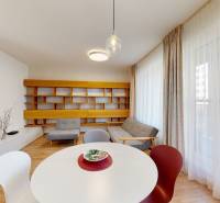 3D prehliadka, prenájom novostavby 4i bytu, Hany Ponickej, Bory - Obývacia izba s podlahou s dreveným dekorom, sedačkou a originálnym nástenným regálom.