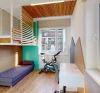 3D prehliadka, prenájom novostavby 4i bytu, Hany Ponickej, Bory - Detská izba s posteľou, písacím stolom, kobercom, podlahou s dreveným dekorom a bicyklom.