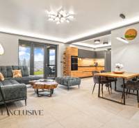 ALL INCLUSIVE I NOVOSTAVBA 4- IZBOVÝ RD SMART HOME - MOSTOVÁ (GA) - Obývačka s kuchyňou v rodinnom dome, podlaha s dreveným dekorom, pohovka a stolík.