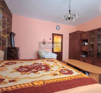 Predaj, rodinný dom Kľačno - ZNÍŽENÁ CENA - EXKLUZÍV... - Interiér rodinného domu s dreveným nábytkom, kobercom a posteľou s farebným prehozom.