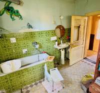 Na predaj 4-izbový rodinný dom v Brodzanoch – pozemok 1236 m² - Kúpeľňa rodinného domu s vaňou, zelenými obkladačkami a poličkou s kozmetikou.