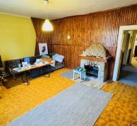 Na predaj 4-izbový rodinný dom v Brodzanoch – pozemok 1236 m² - Obývacia izba v rodinnom dome s krbom a dreveným obkladom stien.