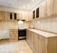 Výborná poloha, skvelá dispozícia – 3-izbový byt v Trebišove - Kuchyňa v 3-izbovom byte s dreveným dekorom skríň a dlažbou.