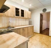 Výborná poloha, skvelá dispozícia – 3-izbový byt v Trebišove - Kuchyňa v 3-izbovom byte s kuchynskou linkou a podlahou s dreveným dekorom.