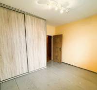 Výborná poloha, skvelá dispozícia – 3-izbový byt v Trebišove - Izba obsahuje vstavanú skriňu a podlahu s dreveným dekorom v 3-izbovom byte.