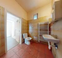 Veľký priestranný pozemok o rozlohe 7445 m2, Jelka  - Kúpeľňa so sanitou, umývadlom a radiátorom v rodinnom dome s dlaždicami.