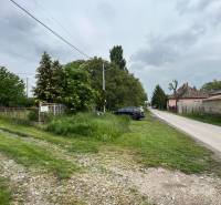 Veľký priestranný pozemok o rozlohe 7445 m2, Jelka  - Cesta v Jelke na Slanej doline vedľa rodinného domu s automobilom a zeleňou.