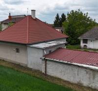 Veľký priestranný pozemok o rozlohe 7445 m2, Jelka  - Rodinný dom v Jelke na Slanej doline s červenou strechou a priľahlými stavbami.