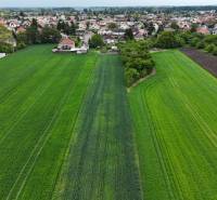 Veľký priestranný pozemok o rozlohe 7445 m2, Jelka  - Polia a domy v Jelke na Slanej doline, vidiecky charakter a rozľahlé zelené plochy.