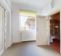 Veľký priestranný pozemok o rozlohe 7445 m2 s RD, Jelka  - Interiér rodinného domu s dverami vedúcimi do kúpeľne a radiátorom pod oknom.