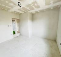 NOVOSTAVBA V CENE 3IZB BYTU - Izba v rodinnom dome so svetlými stenami a holou podlahou.