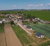 NOVOSTAVBA V CENE 3IZB BYTU - Letecký pohľad na rodinné domy v Malých Ripňanoch uprostred poľnohospodárskej krajiny.