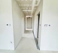 NOVOSTAVBA V CENE 3IZB BYTU - Chodba v rodinnom dome s bielymi stenami, bez podlahovej krytiny.