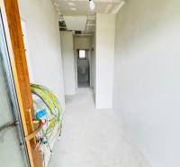 NOVOSTAVBA V CENE 3IZB BYTU - Chodba v rodinnom dome s neomietnutými stenami a rozvodmi elektroinštalácie.