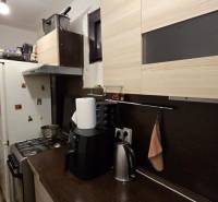 AKCIA - 2 Rodinné domy za cenu jedného obec Veľká Mača  - Kuchyňa v rodinnom dome s dreveným dekorom, obsahujúca spotrebiče, skrinky a odpadkový kôš.