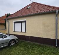 AKCIA - 2 Rodinné domy za cenu jedného obec Veľká Mača  - Rodinný dom na Hlavnej ulici vo Veľkej Mači s automobilom na trávniku.