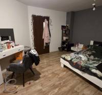 AKCIA - 2 Rodinné domy za cenu jedného obec Veľká Mača  - Spálňa s posteľou, písacím stolom a podlahou s dreveným dekorom v rodinnom dome.