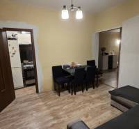 AKCIA - 2 Rodinné domy za cenu jedného obec Veľká Mača  - Obývacia izba v rodinnom dome s podlahou s dreveným dekorom, stolom a pohovkou.