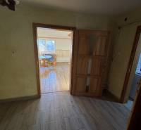 Skrytý raj v srdci prírody - Interiér rodinného domu s podlahou s dreveným dekorom a pohľadom do miestnosti.