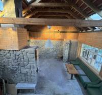 Skrytý raj v srdci prírody - Kamenné steny, drevený strop a sedenie v rodinnom dome.