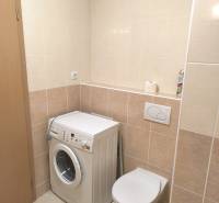 Na dlhodobý prenájom 2-izbový byt - kompletne zariadený, klimatizovaný - Kúpeľňa v 2-izbovom byte so svetlými dlaždicami, práčka a závesné WC.