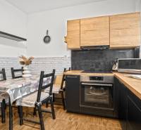 NA PREDAJ 3-IZBOVÝ BYT S PIVNICOU, SENEC - Kuchyňa s dreveným dekorom, jedálenským stolom a spotrebičmi v 3-izbovom byte.