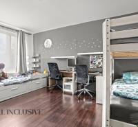 NA PREDAJ 3-IZBOVÝ BYT S PIVNICOU, SENEC - Detská izba v 3-izbovom byte s palandou, stolom a podlahou s dreveným dekorom.