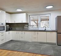 Prenájom, rodinný dom Nová Baňa - NOVOSTAVBA - EXKLU... - Kuchyňa v rodinnom dome s modernými spotrebičmi a podlahou s dreveným dekorom.