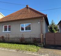 PREDAJ - RODINNÝ DOM - MACHULINCE - Rodinný dom v Machulinciach s červenou škridlovou strechou, bielymi oknami a záhradkou.