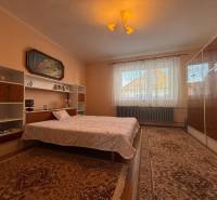 PREDAJ - RODINNÝ DOM - MACHULINCE - Spálňa s kobercami, posteľou, policami a obrazom v rodinnom dome.