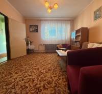 PREDAJ - RODINNÝ DOM - MACHULINCE - Obývacia izba v rodinnom dome s kobercovou podlahou, nábytkom a záclonami.