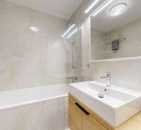 Kvalitne rekonštruovaný byt vo výbornej lokalite Petržalky - Kúpeľňa v 3-izbovom byte s obkladom, vaňou, umývadlom a zrkadlom.