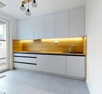 Kvalitne rekonštruovaný byt vo výbornej lokalite Petržalky - Kuchyňa v 3-izbovom byte s dreveným dekorom a svetlým zariadením.