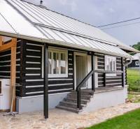 Rekreačná drevenica v obci Legnava na predaj - Chata v Legnave s drevenou fasádou a vydláždenou terasou, obklopená zeleňou a prírodou.