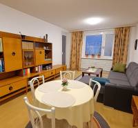 Predaj 4 izbový byt v Starej Sásovej - Obývacia izba v 4-izbovom byte s podlahou s dreveným dekorom, štýlovým nábytkom a jedálenským stolom.