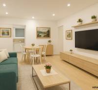 Predaj 4 izbový byt v Starej Sásovej - Obývacia izba v 4-izbovom byte s podlahou s dreveným dekorom, pohovkou a stolíkom.