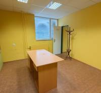 NA PRENÁJOM KOMERČNÝ PRIESTOR (80m2) V CENTRE SENICE - Žlté steny kancelárie s dreveným nábytkom, podlaha s dreveným dekorom, vešiak.