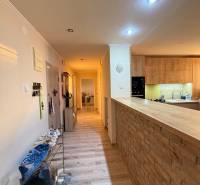 EXKLUZÍVNE - Veľký 3i byt s benefitmi rodinného domu, Boleráz - Chodba s podlahou s dreveným dekorom vedie k kuchyni v 3-izbovom byte.