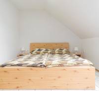 Predaj Exkluzívna ponuka elegantného penziónu s hostincom - Posteľ s dreveným dekorom a nočnými stolíkmi v Hotely a penzióny.